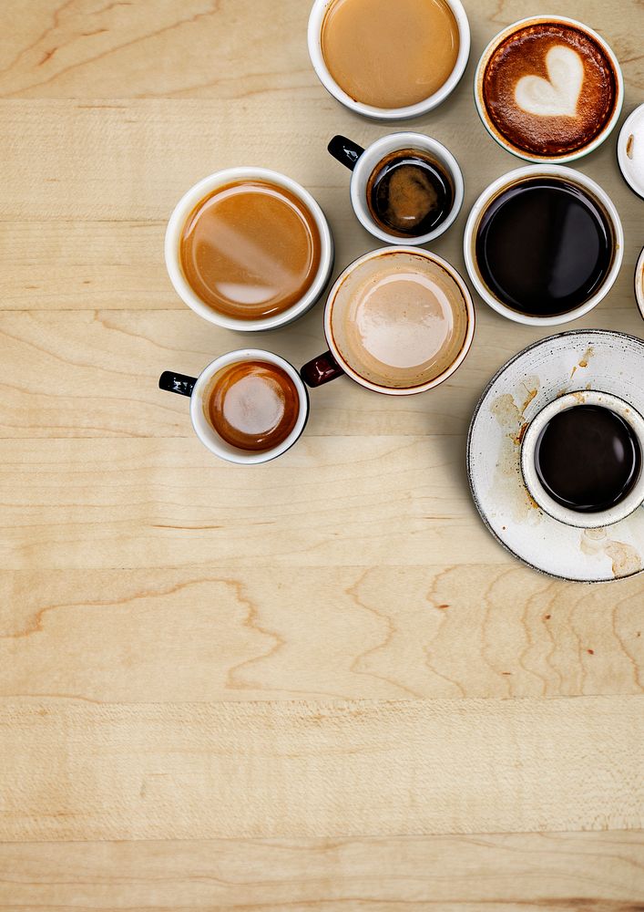 Assorted coffee cups on a light brown wooden board