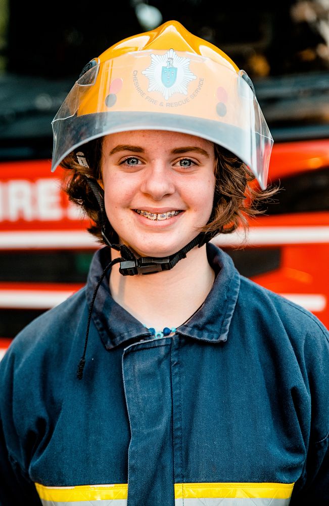 Smiling female firefighter, July 23, 2019, Sandbach, UK. Original public domain image from Flickr