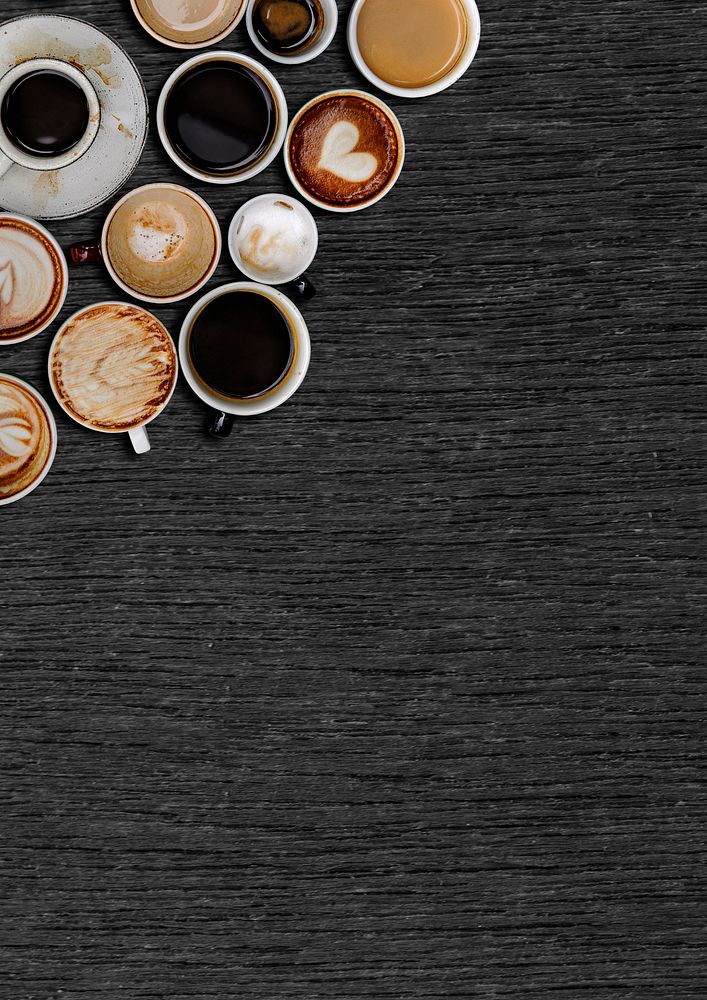 Assorted coffee cups on a black wooden plank textured background