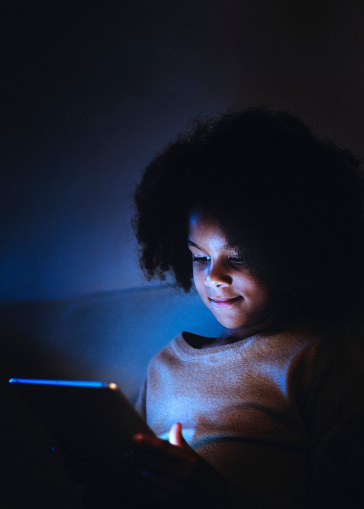 Girl using electronic tablet at night