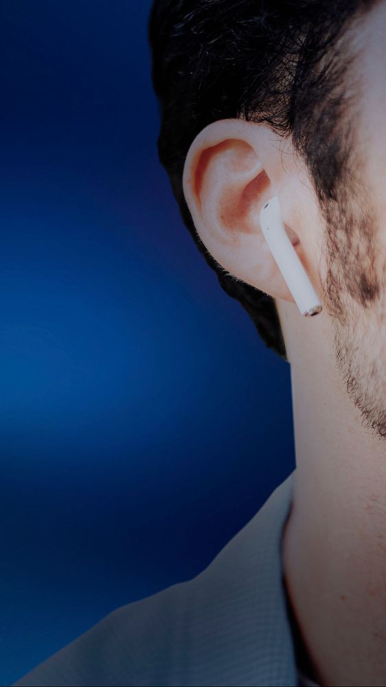 American man listening to music on wireless earphones closeup