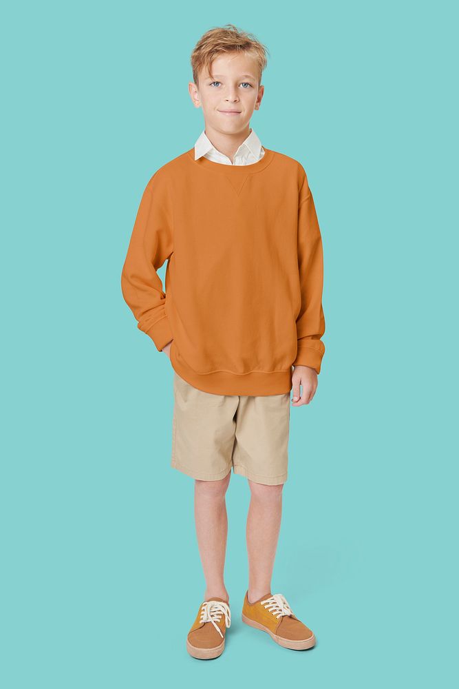 Boy wearing casual orange sweatshirt in studio