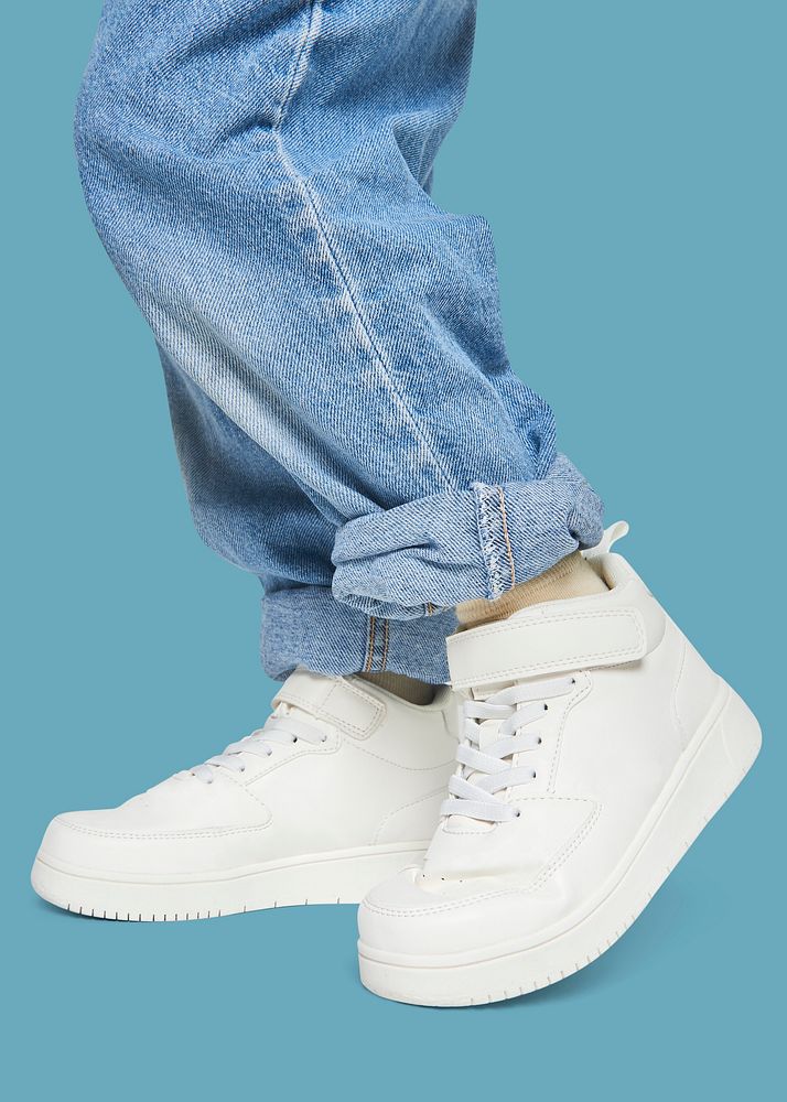 Child with jeans white sneakers studio shot