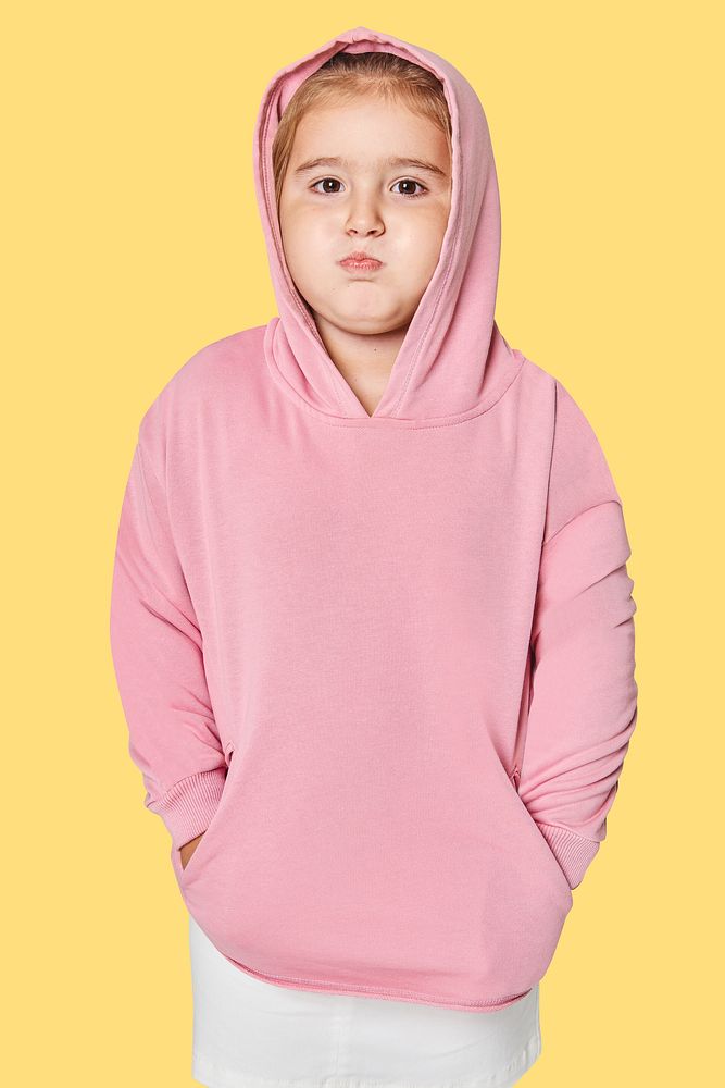 Little cute girl in pink hoodie in studio