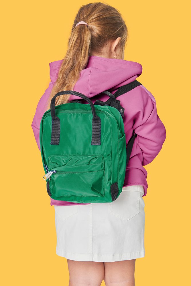 Girl with green school bag in studio