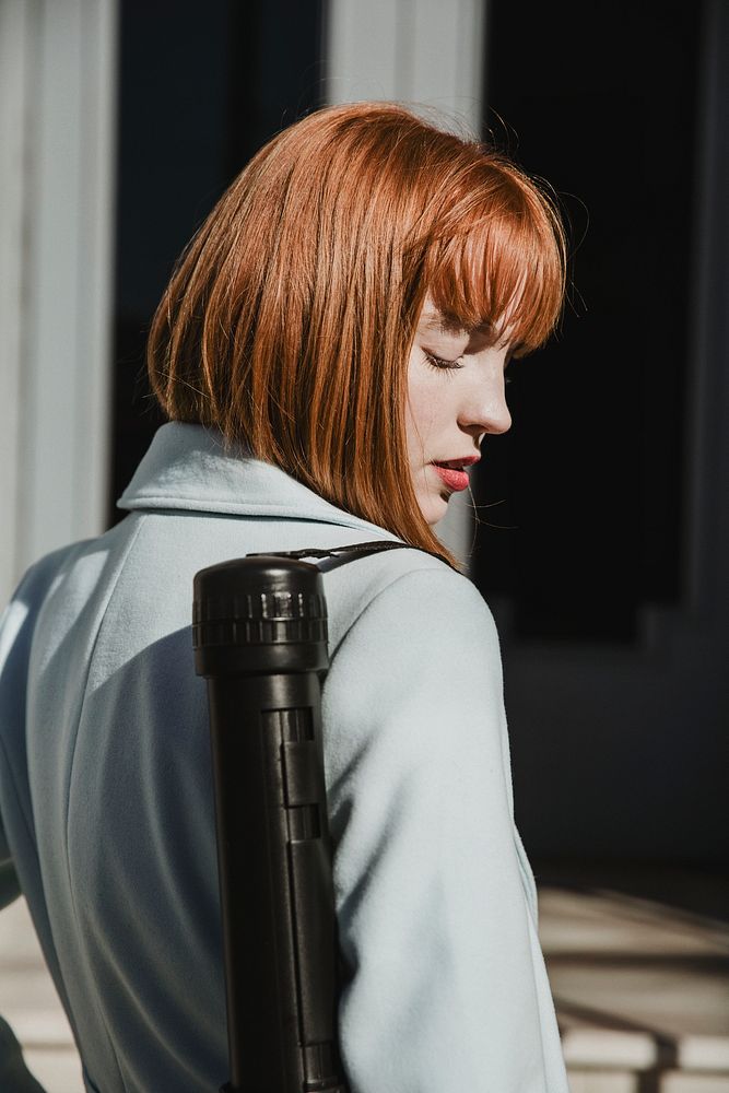 Woman architect carrying poster tube on shoulder