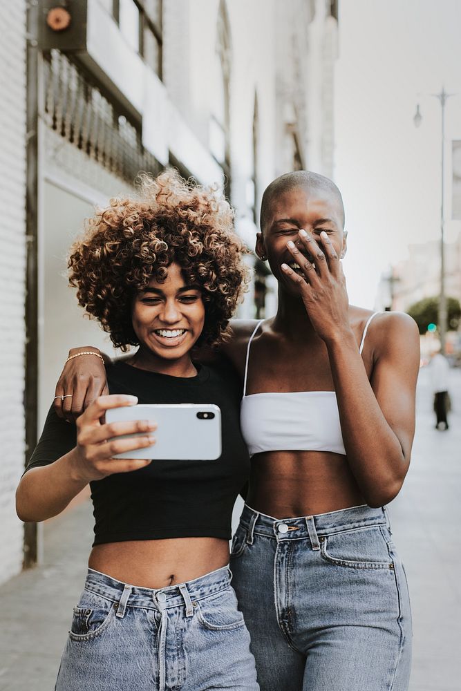 Black women taking selfies with smartphone