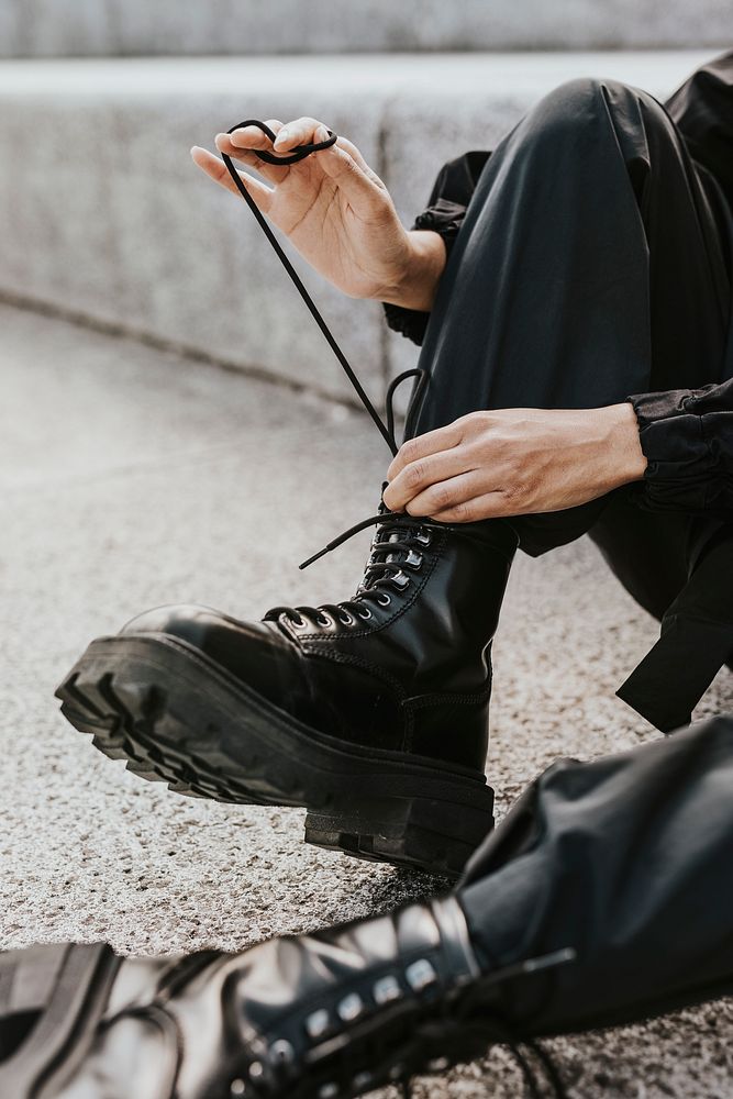 Man tying boots shoelaces, street fashion