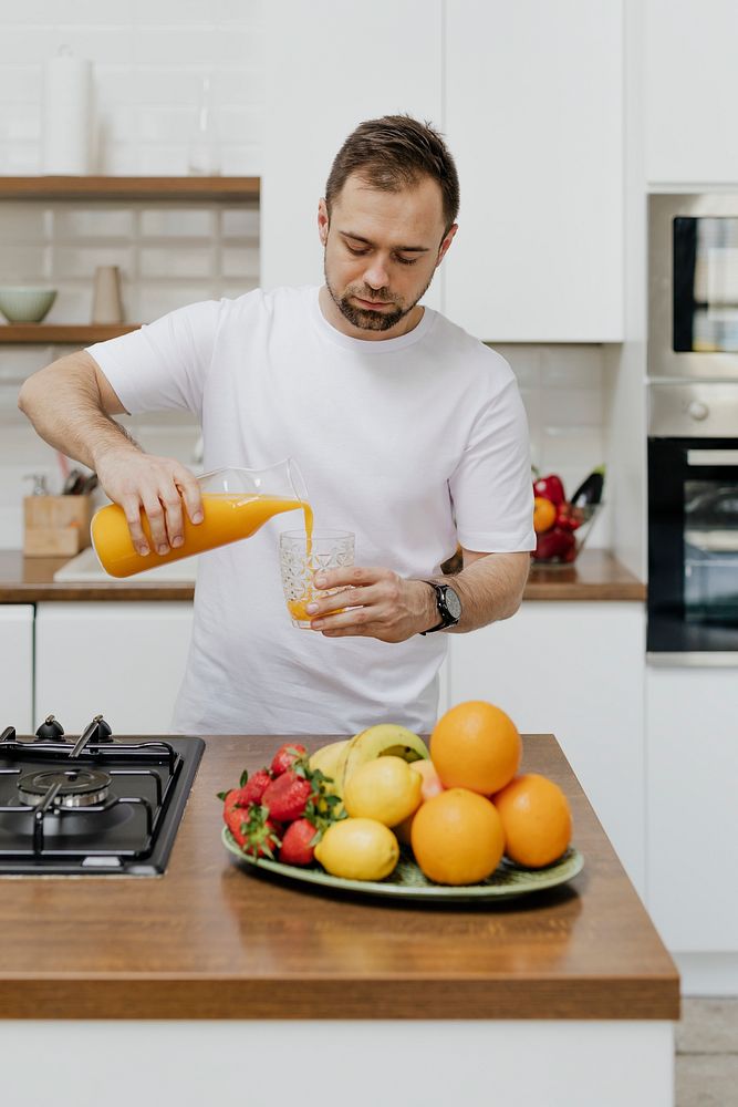 Man pouring orange juice into a glass