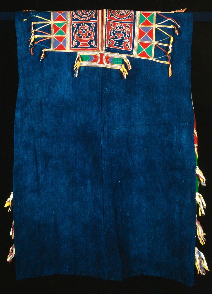 tunic with solid blue body with applique embroidered decorative side panels, shoulders and collar; decorative theme of…