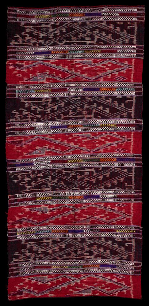 wide alternating ikat panels with maroon and rust ground colors; woven white, orange, purple, red, green, yellow and…