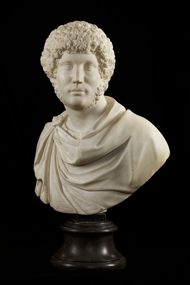 bust of a man with thick curly hair, beard under his chin and moustache; draping garment with round brooch at PR shoulder;…