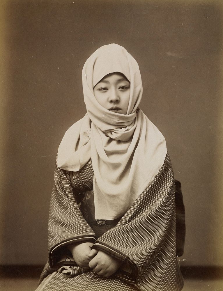 portrait of a young woman wearing a striped kimono and a white scarf wrapped around her head and neck. Original from the…