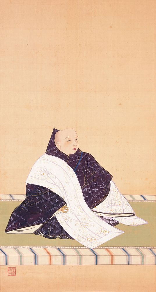 3/4 view of monk in purple and white robes facing PL; monk is seated on green mat with white, blue, green, and orange…