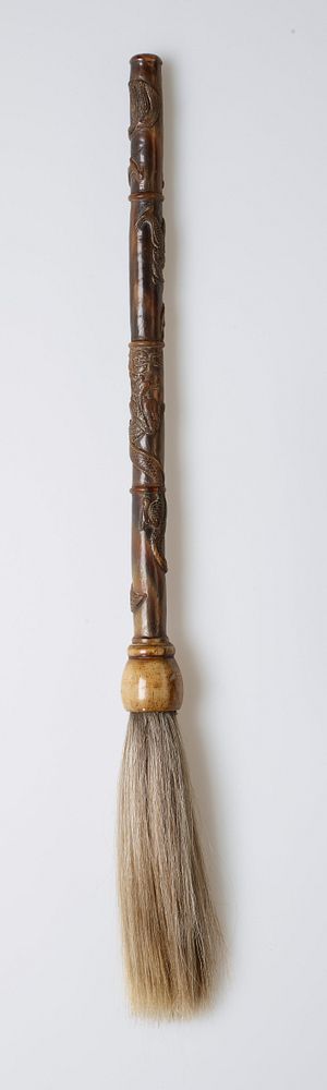 horn brush with carved handle with two dragons; handle's length is divided into four sections; tip of handle is smooth and…