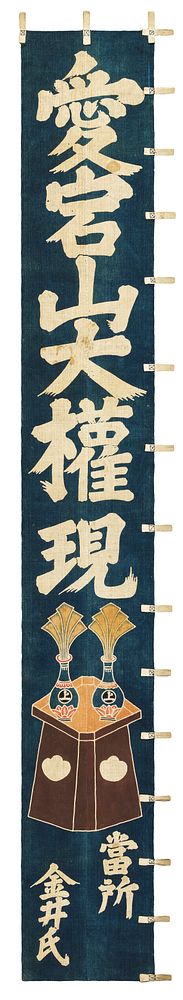 indigo-dyed cotton banner with inscription in Japanese characters in white; brown table or dais with two vases with fanned…