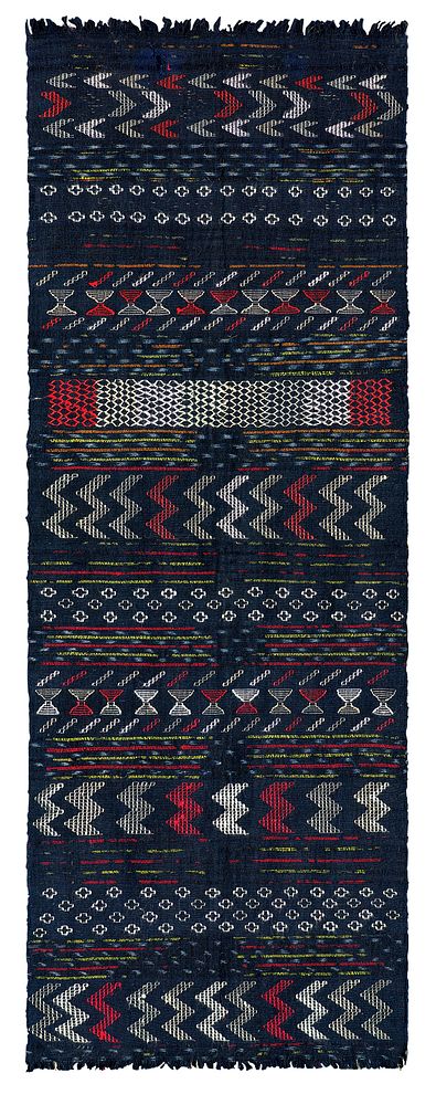 Rectangular, navy blue scarf with fringed ends; woven with white, green, gray, and red geometric patterns (arrows, crosses…