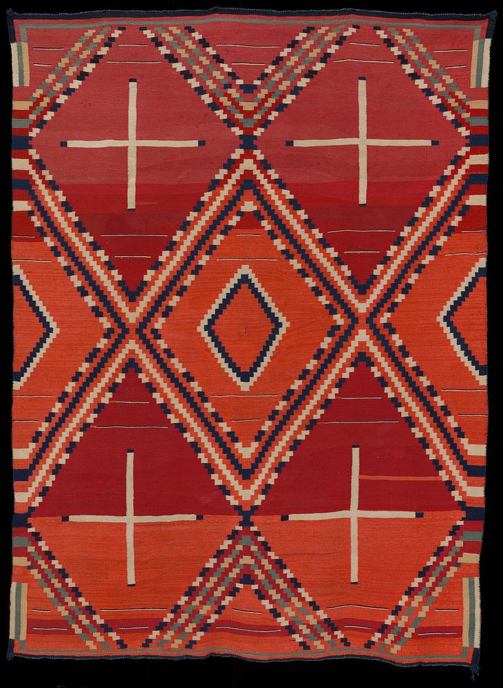 Red textile with blue, green, tan, and white woven pattern; pattern consists of four white crosses with blue tips in…