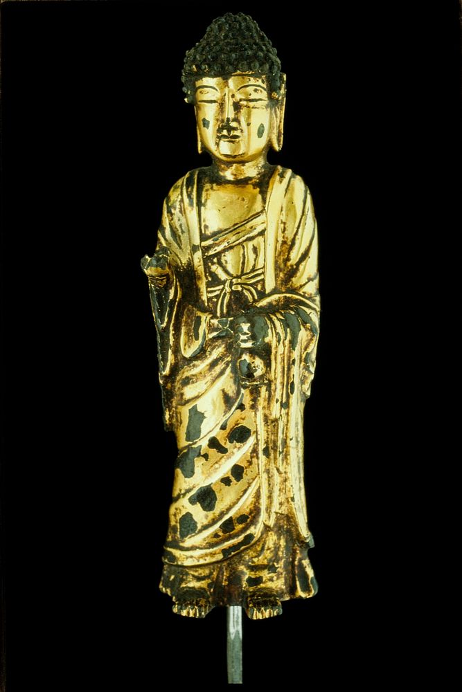 gilt-bronze Buddha; one hands holds holy water bottle, other is damaged; meant to be seen from front, back has three open…