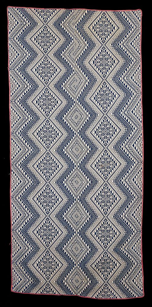 woven fabric; navy blue on white ground; geometric design; 2 panels; seamed center; edges bound with light red. Original…