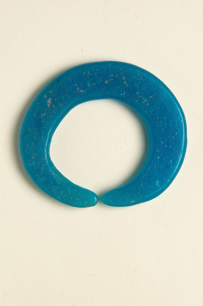 C-shaped; light blue glass with flat sides; slightly uneven shape. Original from the Minneapolis Institute of Art.