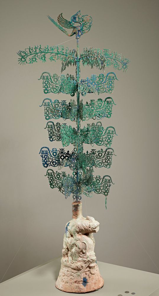 base with iridescent light green glaze and 2 animals, one standing on the back of the other; long post topped with openwork…