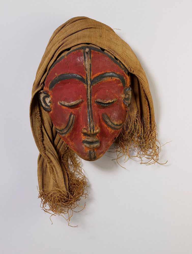female face with closed eyes, long nose and small ears; red with black details; cloth over head. Original from the…