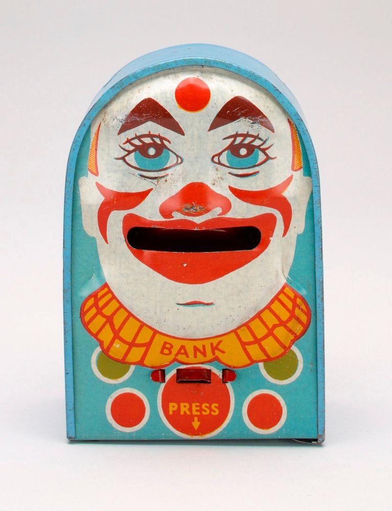 light blue rectangular box with round roof; face of clown on front side; clown has pointed triangular eyebrows and a red dot…