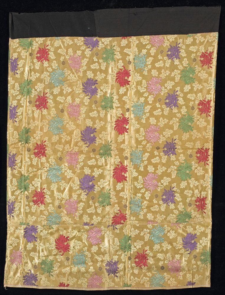 woven overall crysanthemum pattern on tan field in pink, red, green, purple, aqua; 9 1/2" addition on bottom; black cotton…