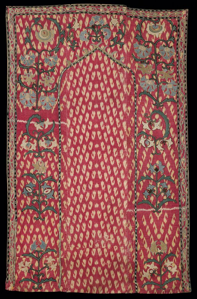 red ground with yellow paisley shapes; embroidered border of flowers around an archway; running border at left, right and…