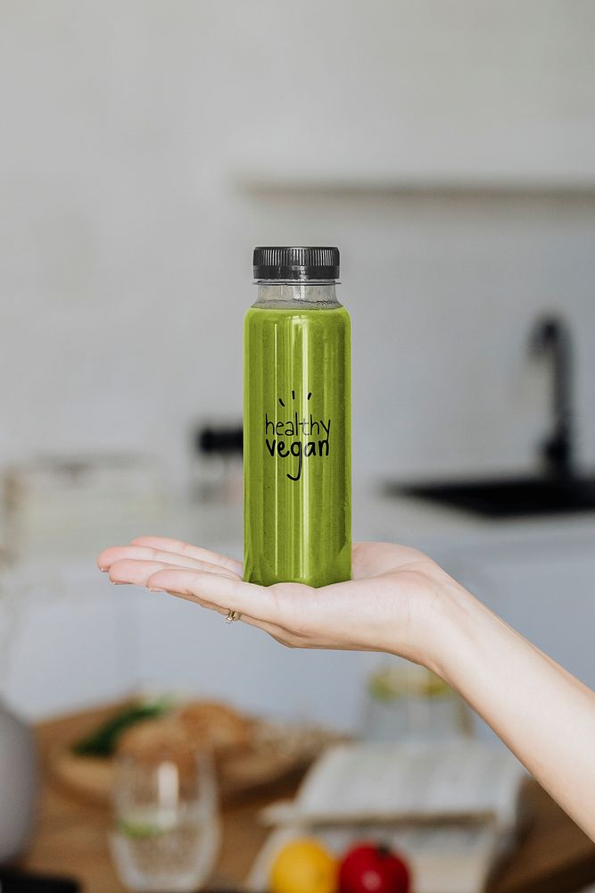 Woman holding a bottle of celery juice mockup