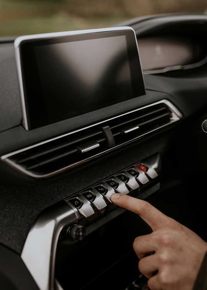 Hand pressing car control panel photo