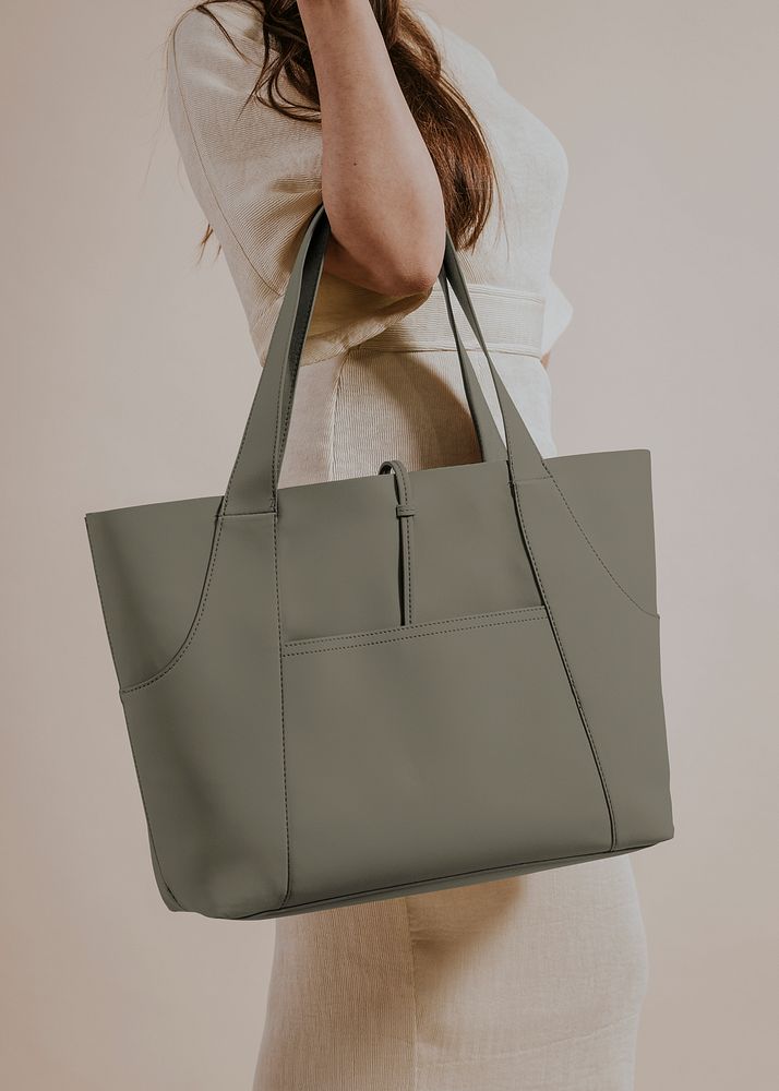 Woman holding green leather bag, studio shoot