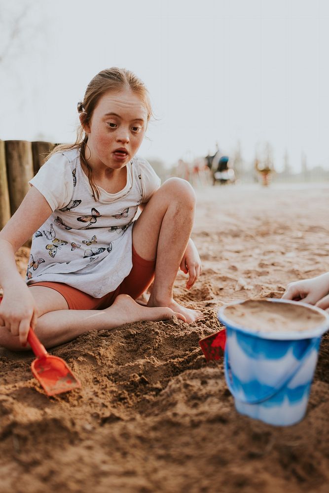 Girl with Down Syndrome playing at beach