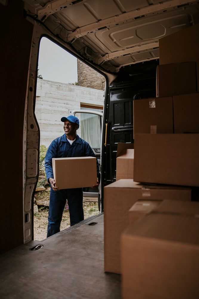 Removal service worker unloading box from the van