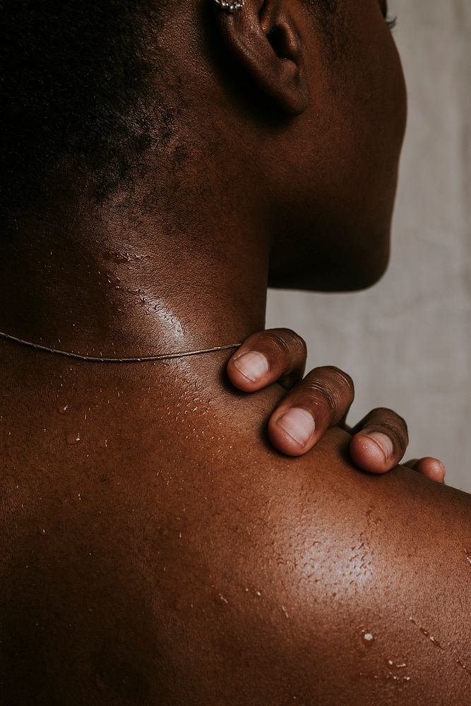African woman touching shoulder, wet skin photo