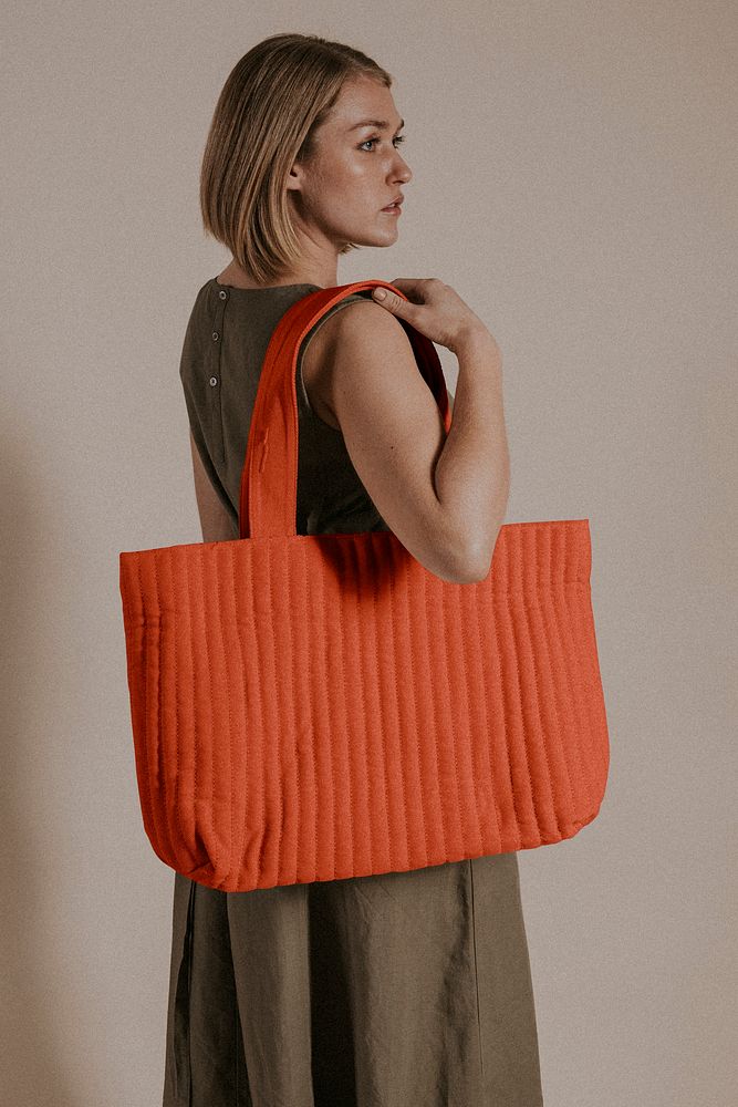 Woman holding orange bag, studio shoot