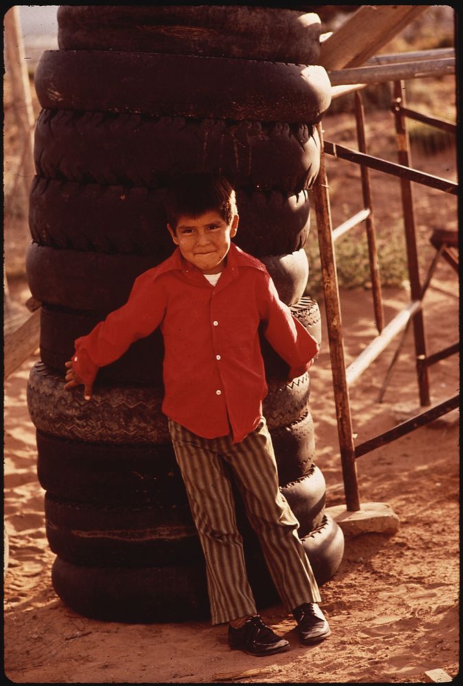 Navaho Boy Leans Against Tower of Discarded Tires. Lack of Disposal Facilities Is A Common Problem in Remote Areas of the…