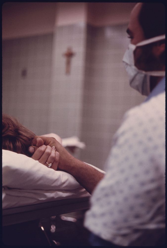 A Husband Holds His Wife's Hand During Delivery of Their Baby in Loretto Hospital in New Ulm, Minnesota.