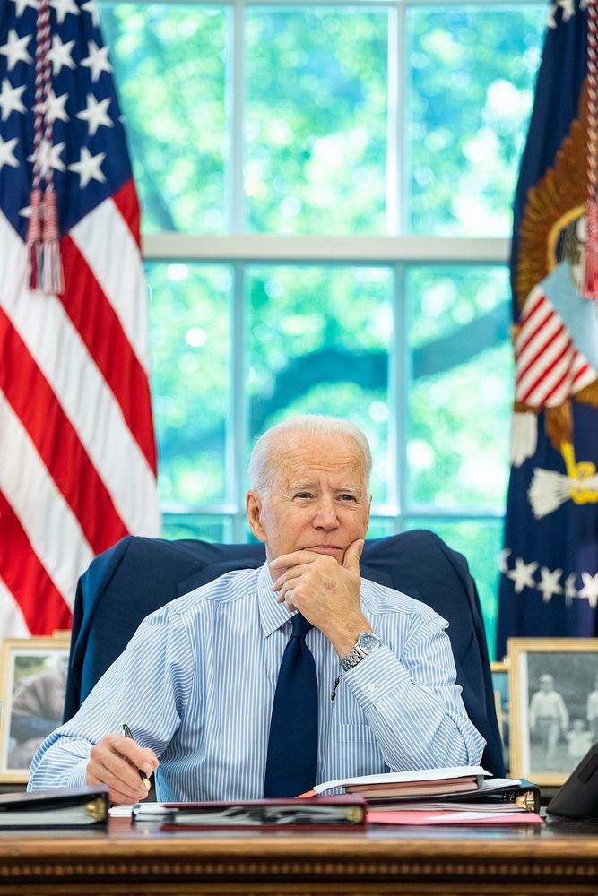 President Joe Biden listens as he talks on the phone with U.S. Senator Tom Carper, D-Del., during congressional call time on…