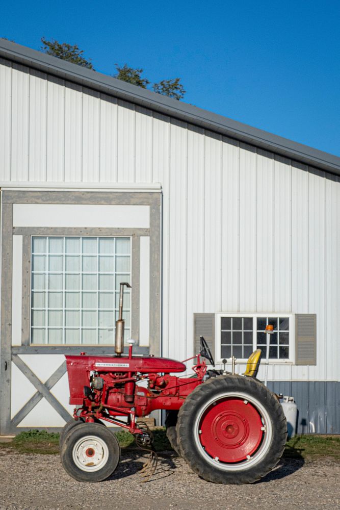 Red harvester tractor sits on the Sang Lee Farms. Original public domain image from Flickr