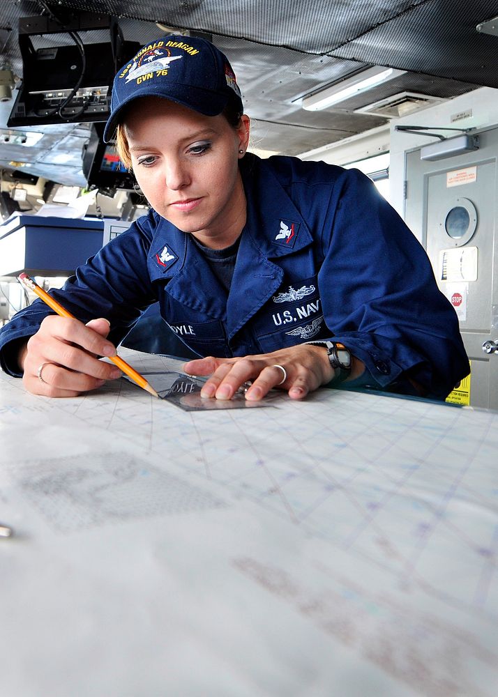 U.S. Navy Quartermaster 3rd Class Jennifer Boyle plots a chart on the bridge of the aircraft carrier USS Ronald Reagan (CVN…