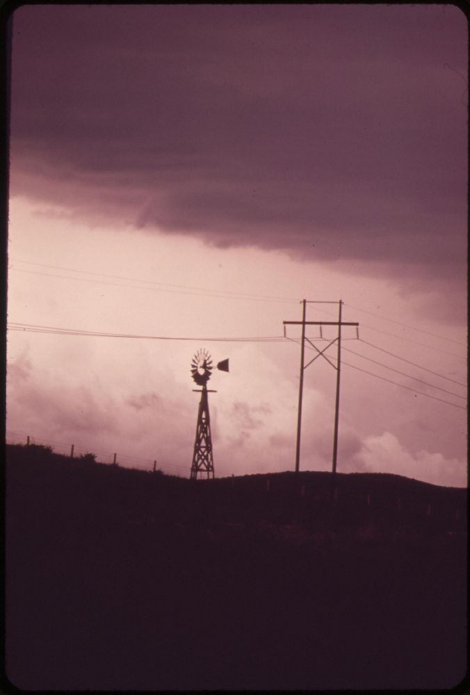 Windmill and power lines near the Dave Johnston Power Plant, 06/1973. Photographer: Norton, Boyd. Original public domain…