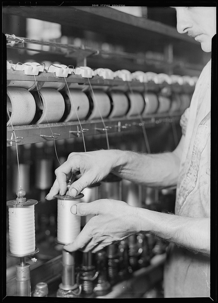 Rayon yarn being wound from one bobbin on to another and being twisted, March 1937. Photographer: Hine, Lewis. Original…