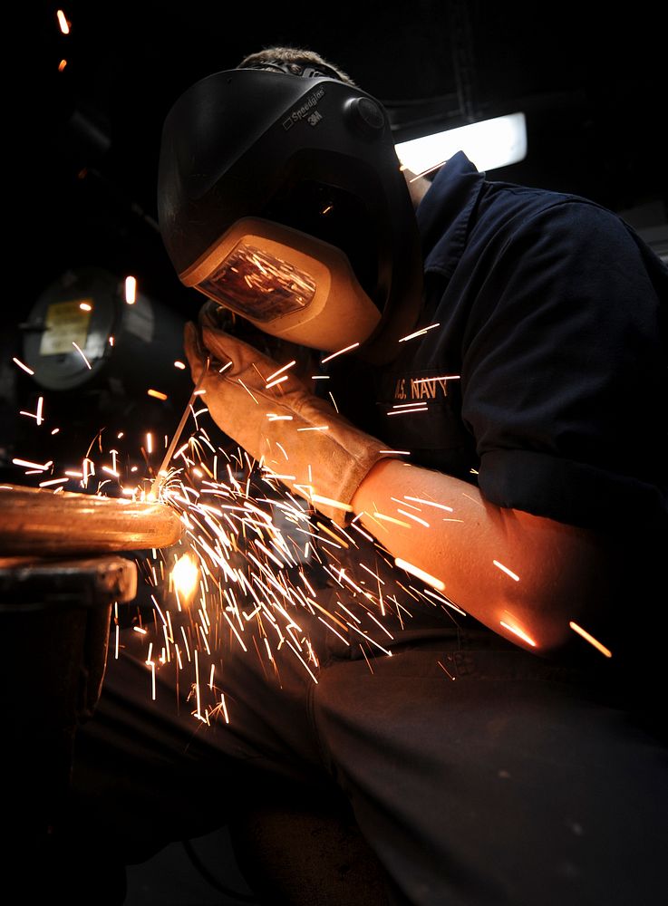 U.S. Navy Hull Maintenance Technician Fireman George Weckman fabricates a coat rack in the weld shop aboard the aircraft…