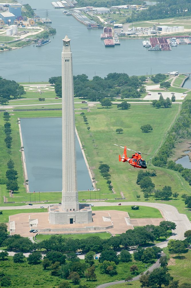 U.S. Coast Guardsmen pass the San Jacinto Monument during a training flight aboard an MH-65D Dolphin helicopter over the…