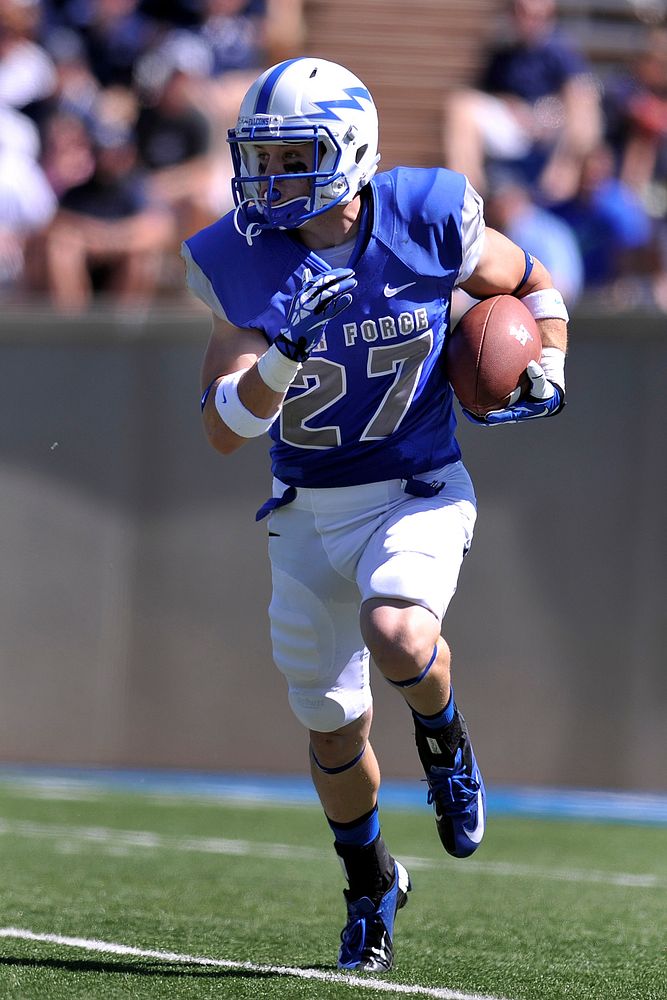 Ty MacArthur, a senior football player for the U.S. Air Force Academy Falcons, runs the ball down the field during a…