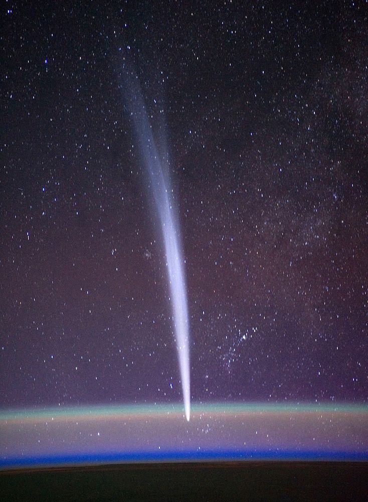Comet Lovejoy is visible near Earth's horizon behind airglow in this nighttime image photographed by NASA astronaut Dan…