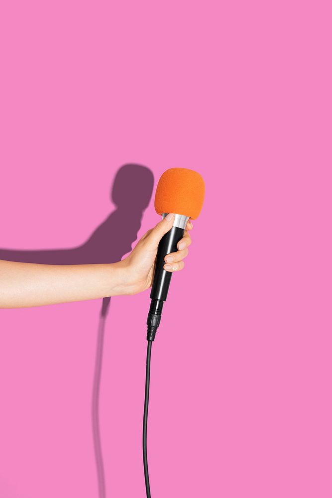 Pink music background, hand holding microphone photo