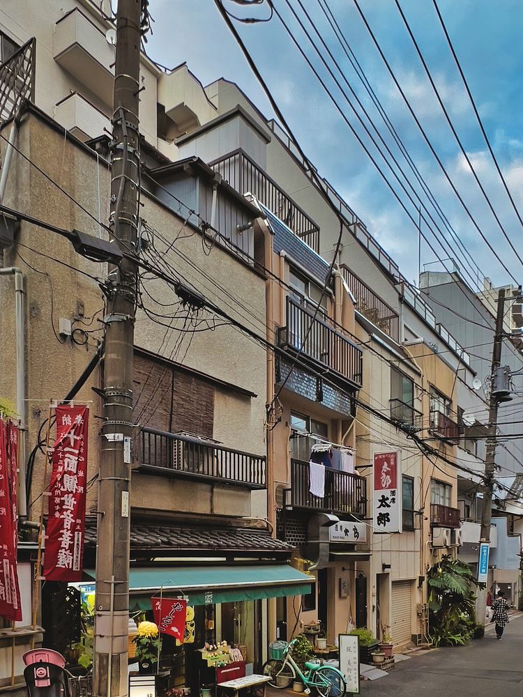 Aging Low-Rise Buildings, Tokyo, JapanLooking down a street lined with aging low-rise buildings under a blue sky in Yushima…